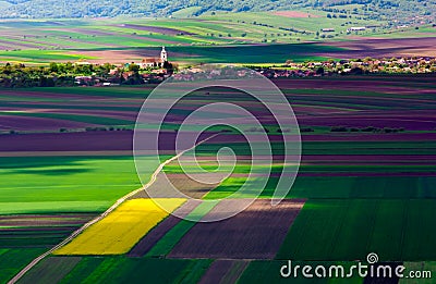 Agricultural fields on a summer day with Transylvania village Stock Photo