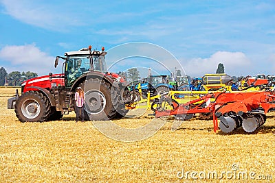 Agricultural machinery at the exhibition, powerful multi-row disc harrow with a tractor against the backdrop of an agricultural Stock Photo