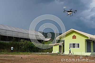 agriculture drone flying & spraying liquid fertilizer or herbici Editorial Stock Photo