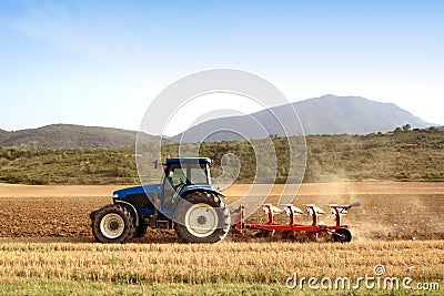 Agriculture plowing tractor on wheat cereal fields Stock Photo