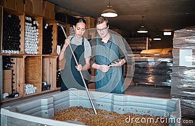 Agriculture, wine and vineyard workers in the alcohol business, press grapes in distillery plant. Sustainability, nature Stock Photo