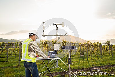 Agronomist using tablet computer collect data with meteorological instrument to measure the wind speed, temperature and humidity Stock Photo