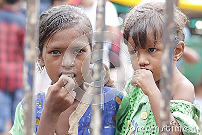 Ahemdabad, Gujarat, India - 20th june, 2019: Poor indian helpless street girl holding little kid in hand looks at camera, seeking Editorial Stock Photo