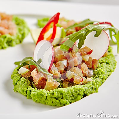 Ahi Tuna Seviche with Radish Slices and Rucola on White Plate Stock Photo