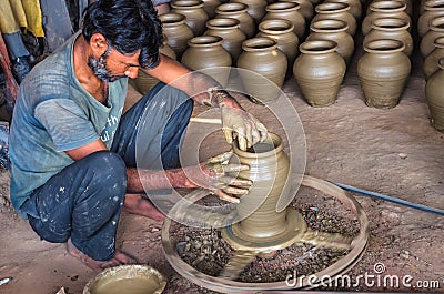 Unidentified potter making clay water pots on pottery wheel. Editorial Stock Photo