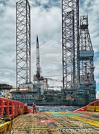 AHTS or offshore vessel towing jack up rig at sea Editorial Stock Photo