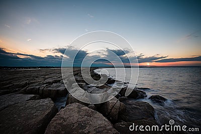 AI generated illustration of a breathtaking sunset view of a rocky shoreline, with crashing waves Cartoon Illustration