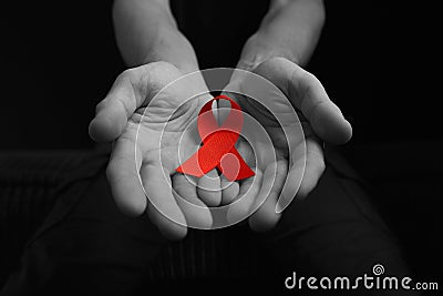 Aids ribbon on hands, hiv Stock Photo