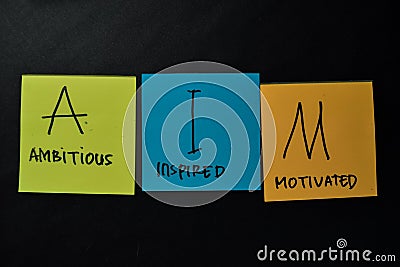 AIM - Ambitious Inspired Motivated write on sticky notes isolated on office desk Stock Photo