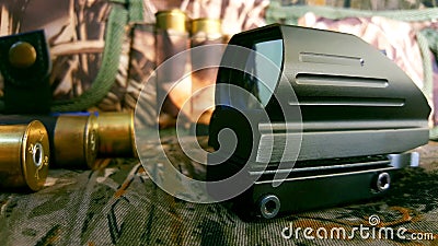 Aims red dot sight, ammunition and bandoleer on a camouflage background, wallpaper Stock Photo