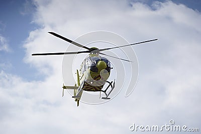 The air ambulance, service arrives at the scene of an accident. Flying yellow medical ambulance helicopter. Editorial Stock Photo