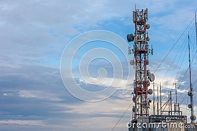 Air broadcast antenna towering high in top of the building. Microwave receiver mounted in the galvanized steel. Cell site reaching Stock Photo