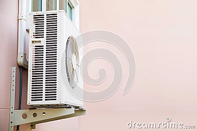 Close-up external split wall type of outdoor home air conditioner compressor unit installed on the outside of the Stock Photo