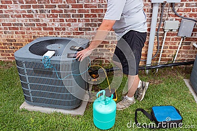 Air Conditioner maintenance with technician adding refrigerant Stock Photo