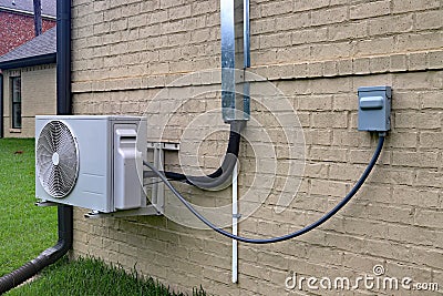 Air Conditioner mini split system next to home with brick wall Stock Photo