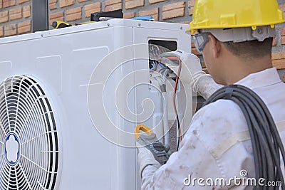 Air conditioner repairmen work on home unit Stock Photo
