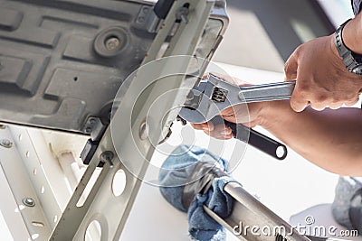 Air Conditioning Repair, technician man hands using a wrench fixing modern air conditioning system Stock Photo