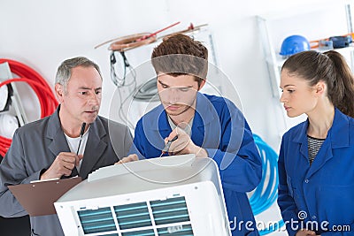 Air conditioning repairmen discussing problem with compressor unit Stock Photo