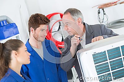 Air conditioning repairmen working on compressor unit Stock Photo