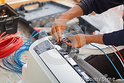 Air conditioning technicians install new air conditioners in homes, Repairman fix air conditioning systems, Male technician Stock Photo