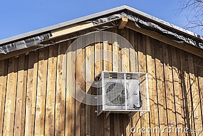 air conditioning on the wall of wooden cottage.modern climate systems Stock Photo