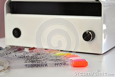 Air hood for work in the manicure salon and a palette of colors of lacquer on white table Stock Photo