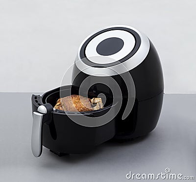 Air fryer machine with fried pork knuckle Stock Photo