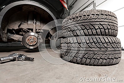 Air gun to tighten a tire bolts on a suspended car at an auto shop Stock Photo