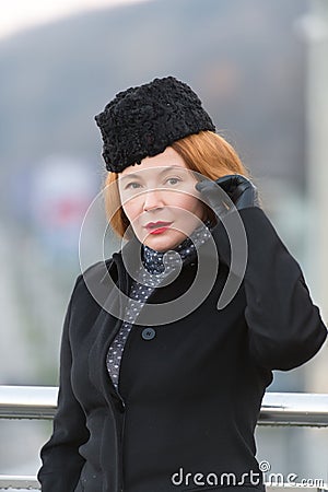 Air-hostess welcome you. Red hair lady in hat. Portrait of lady in coat.Lady love hat.Spring fashion for female. Styled women Stock Photo