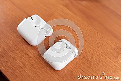 Air Pods Pro. with Wireless Charging Case. New Airpods pro on wooden background. Air pods. Copy space Stock Photo