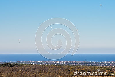 Airborne troops a mass parachute drop over the sea. On a blue sky background. Stock Photo