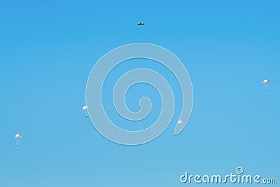 Airborne troops a mass parachute drop over the sea. On a blue sky background. Stock Photo