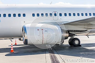 Aircraft engine, wing, landing gear and fuselage with portholes Stock Photo
