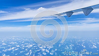 Aircraft wing flying over the blue clouds Stock Photo