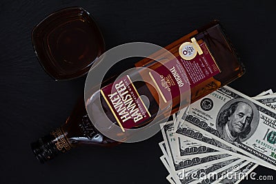 Hankey Bannister blended Scotch whisky bottle, glass and pile of 100 dollar bills Editorial Stock Photo