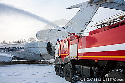 Airfield fire truck extinguishes aircraft after emergency landing in a cold weather Stock Photo