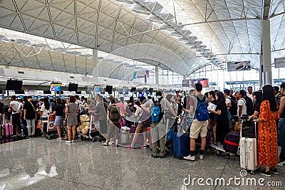Airline passengers checking in at an airline counter at Hong Kong International Airport Editorial Stock Photo