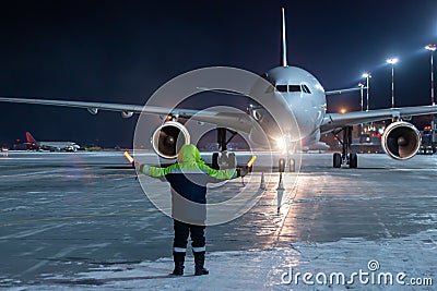 Airliner marshalling at the aiport apron at winter night Stock Photo