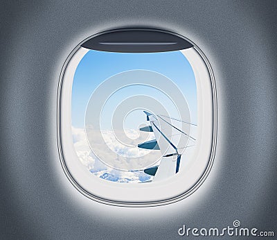 Airplane or aeroplane window with wing and cloudy sky behind Stock Photo