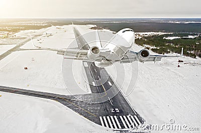 Airplane is climb flight level high view in the air, against the background of the winter airport of the runway, city, snow, fores Stock Photo