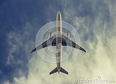 Airplane in the cloudy sky - vintage look. Editorial Stock Photo