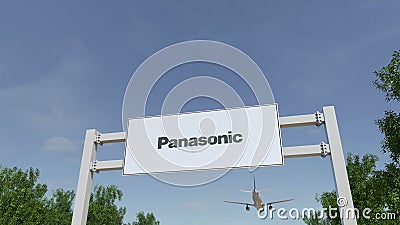 Airplane flying over advertising billboard with Panasonic Corporation logo. Editorial 3D rendering Editorial Stock Photo