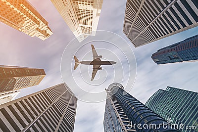 Airplane flying over city business buildings, high-rise skyscrapers Stock Photo