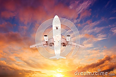 Airplane flying overhead during a black sunset Stock Photo