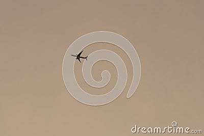 Airplane flying in the sunset sky Stock Photo