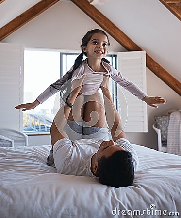 Airplane, fun and happy girl with father on a bed playing, bonding and enjoying the morning indoors. Flying, game and Stock Photo
