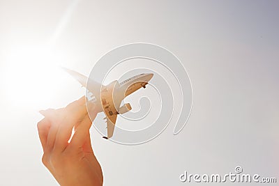 Airplane model in hand on sunny sky. Concepts of travel, transportation Stock Photo