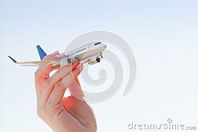 Airplane model in hand on sunny sky. Travel, transportation Stock Photo