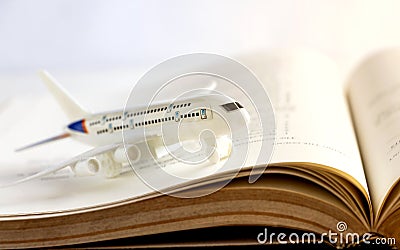 Airplane model on textbook or hardback. The concept of tourism Stock Photo