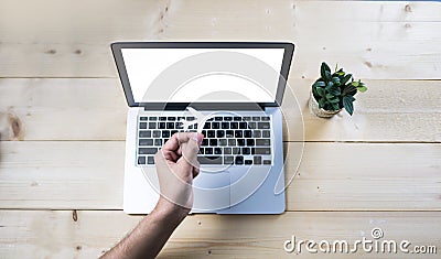 Airplane paper cut holding by hand with empty computer notebook on wooden table Stock Photo